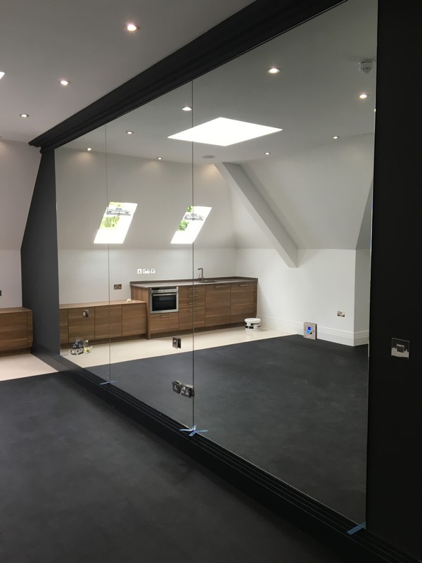 Frameless glass partition in loft conversion by Slough glaziers